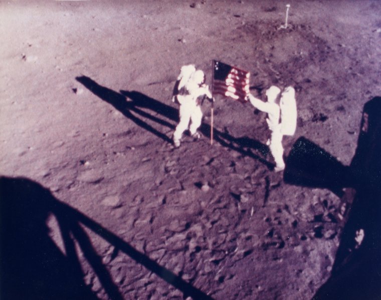  ARMSTRONG and ALDRIN plant the American flag